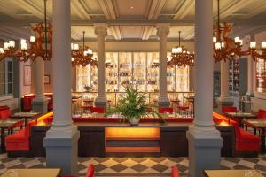 a restaurant with columns and tables and a bar at Helvetia&Bristol Firenze – Starhotels Collezione in Florence