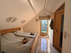 a bedroom with a bed with a dog laying on it at Pure Wellness Bungalows 52 Sauna&Hottub in Ewijk