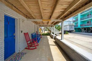 a porch with red chairs and a blue door at Sand Dollar Suites 1 in Carolina Beach +24 photos