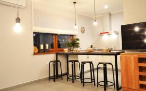 a kitchen with a black counter and bar stools at Apartamenty 66 c in Wisła