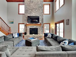 a living room with couches and a stone fireplace at Limitless Joy in Swanton