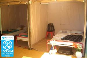 a small room with two bunk beds in it at ZEcamping 4 étoiles chiens acceptés tennis piscine chauffée in Salles-Curan