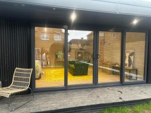 a screened in porch with a chair and a window at The Cabin in St. Ives +1 photo