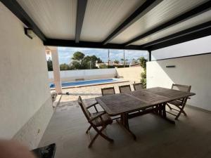 a wooden table and two chairs on a patio at 32 Salamandre in Les tres Cales