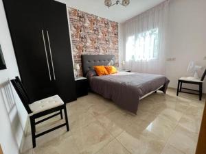 a bedroom with a bed and a brick wall at 32 Salamandre in Les tres Cales +21 photos