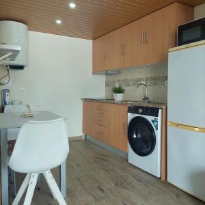 a kitchen with a washing machine and a white chair at HOUSE 4U - Modern Mezzanine Apartment with AC, Wi-Fi and Parking - Abrantes in Abrantes