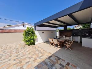 a patio with a table and chairs on a roof at 32 Salamandre in Les tres Cales