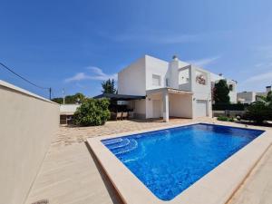 a villa with a swimming pool in front of a house at 32 Salamandre in Les tres Cales