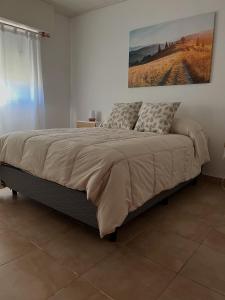 a bed in a bedroom with a painting on the wall at Las Lomitas in Lincoln