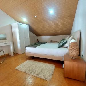 a bedroom with a white bed with a wooden ceiling at HOUSE 4U - Modern Mezzanine Apartment with AC, Wi-Fi and Parking - Abrantes in Abrantes +18 photos
