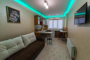 a living room with a couch and a kitchen at Modern apartment on Akademika Sakharova 27a in Ivano-Frankivsk