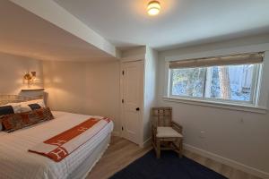 a bedroom with a bed and a window and a chair at Perfectly Scitu8ed - Scituate in Scituate
