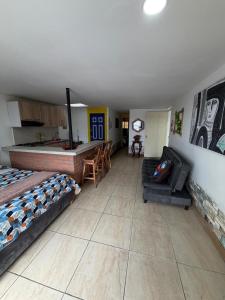 a living room with two beds and a kitchen at Apartahotel Casa Azul Salento in Salento