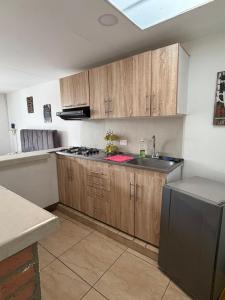 a kitchen with wooden cabinets and a sink and a stove at Apartahotel Casa Azul Salento in Salento