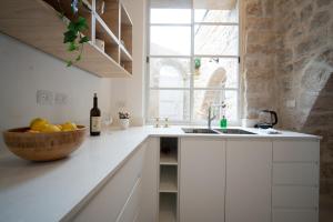a white kitchen with a bowl of fruit and a sink at חקל תפוחין 1 - Hakal-Tapuchin 1 in Safed