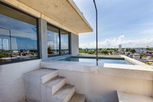 a house with a swimming pool and windows at Hola Donceles Suites in Cancún