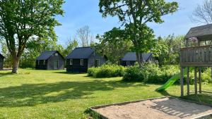 a yard with houses and a green slide at Kappelshamns Veranda och Fritidsboende in Kappelshamn