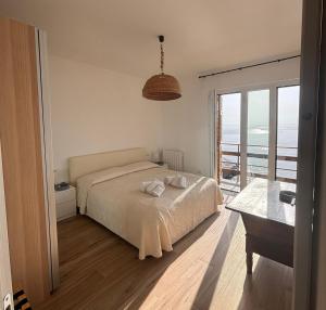 a bedroom with a bed and a view of the ocean at M'illumino d'immenso - MONEGLIA APARTMENTS in Moneglia