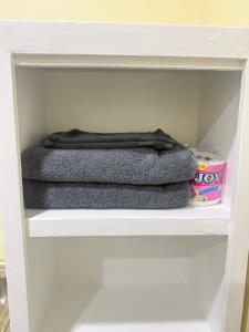 two towels are sitting on a shelf in a closet at Belechl Ranch Studio Rental - Cozy Compact Room with Private Bathroom in Koror