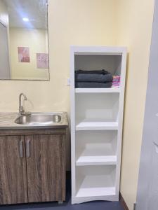a white refrigerator in a kitchen next to a sink at Belechl Ranch Studio Rental - Cozy Compact Room with Private Bathroom in Koror