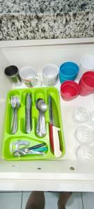 a green tray with utensils on a table at Casa Mineira in Capitólio