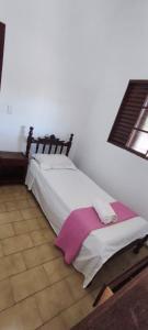 a bedroom with a bed with a blanket on it at Casa Mineira in Capitólio