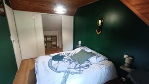 a bedroom with a green wall and a bed at Le Chaudron de Loguivy in Loguivy-Plougras