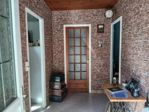a brick hallway with a door and a brick wall at Le Chaudron de Loguivy in Loguivy-Plougras
