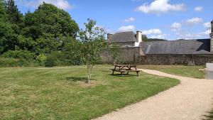 a picnic table in the grass next to a building at Le Chaudron de Loguivy in Loguivy-Plougras
