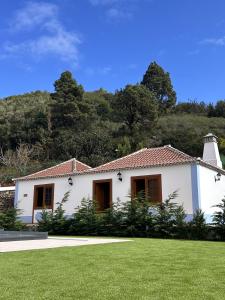 a white house with a green lawn in front of it at Villas Morera in Breña Baja