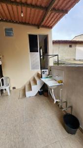 a patio with a table and a bench on a house at Suíte Conforto - Leve, Prático e Acolhedor in Itacaré