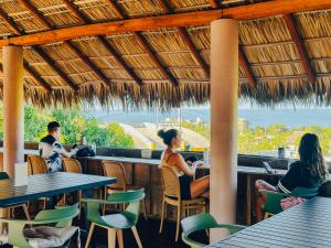 a group of people sitting at a restaurant at Viajero Puerto Escondido Hostel in Puerto Escondido