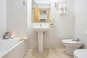 a white bathroom with a sink and a toilet at GuestReady - Domocenter studio with garage in Bormujos