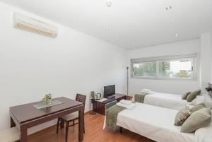 a living room with two beds and a table at GuestReady - Domocenter studio with garage in Bormujos