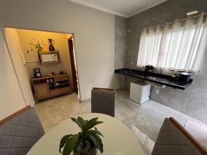 a dining room with a table and a piano at Suítes Brotas in Brotas
