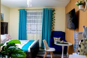 a bedroom with a bed and a table and a chair at Jkia Airport 24 Hours Transit studio next 67hotel in Nairobi