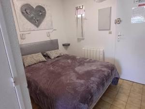 a bedroom with a bed with a heart on the wall at Charmant studio à Balaruc-les-Bains avec parking inclus - FR-1-571-68 in Balaruc-les-Bains