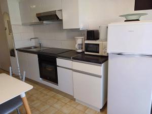 a kitchen with a white refrigerator and a microwave at Charmant studio à Balaruc-les-Bains avec parking inclus - FR-1-571-68 in Balaruc-les-Bains