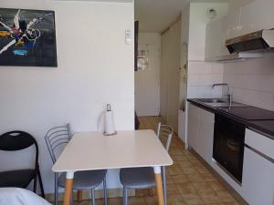 a small kitchen with a white table and chairs at Charmant studio à Balaruc-les-Bains avec parking inclus - FR-1-571-68 in Balaruc-les-Bains