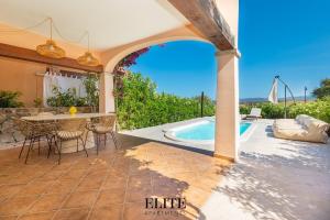 an outdoor patio with a table and a swimming pool at Elite Collection Domo Mea Private Pool in Olbia