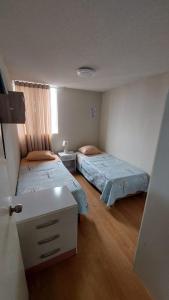 a bedroom with two beds and a window at Apartamento Varela in Lima