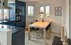 a kitchen with a wooden table and a dining room at 3 Bedroom Gorgeous Home In Stubbekøbing in Stubbekøbing
