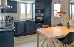 a kitchen with blue cabinets and a wooden table at 3 Bedroom Gorgeous Home In Stubbekøbing in Stubbekøbing