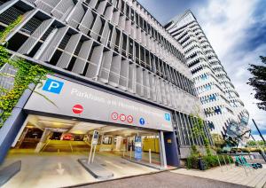 a building with a parking lot in front of it at The Zipper Hotel und Apartments in Düsseldorf