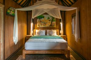 a bedroom with a bed with a canopy at Bedugulhome in Bedugul