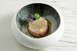 a white bowl with a piece of food in it at Hotel L'Arenella in Giglio Porto