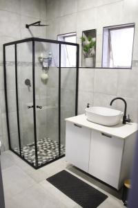 a bathroom with a shower with a sink and a toilet at Aeon Guest House & Spa in Pretoria
