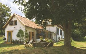 a small white house with a tree in the yard at The charming, bright stable in Neuilly-le-Dien