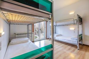 two bunk beds in a room with a window at HI Lousã – Pousada de Juventude in Lousã +40 photos