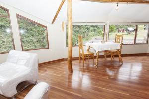 a dining room with a table and chairs and windows at Caisae Eco-Lodge in San Antonio